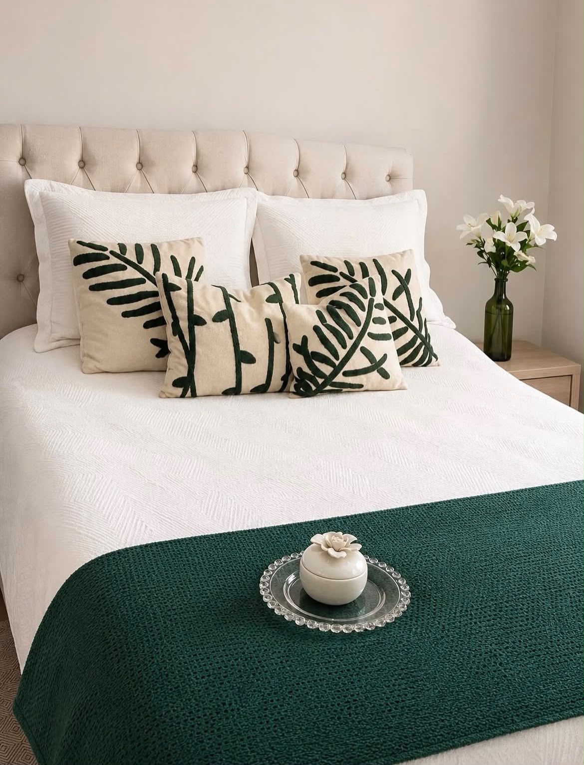 Quarto com roupa de cama branca e detalhes verdes